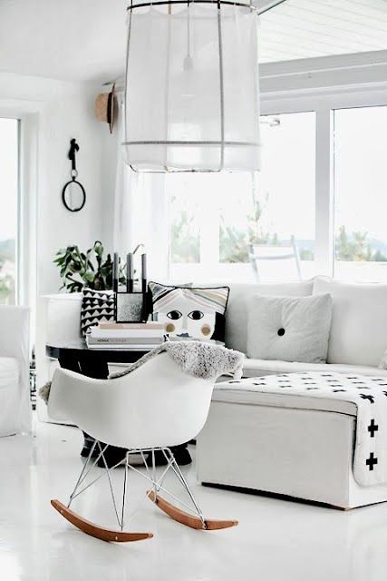 Scandinavian living room with white flooring, Eames rocking chair .