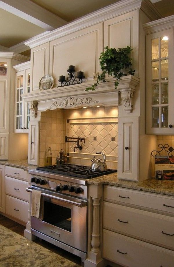 Cooking area with an artificial mantelpiece in a richly decorated French country kitchen DJALEKJ