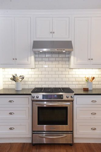 Beveled white kitchen cabinets with white subway tile back wall