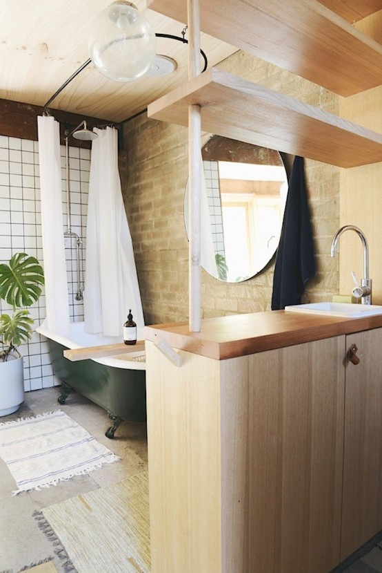 Chic brick bathroom design with a retro green bathtub - DigsDi
