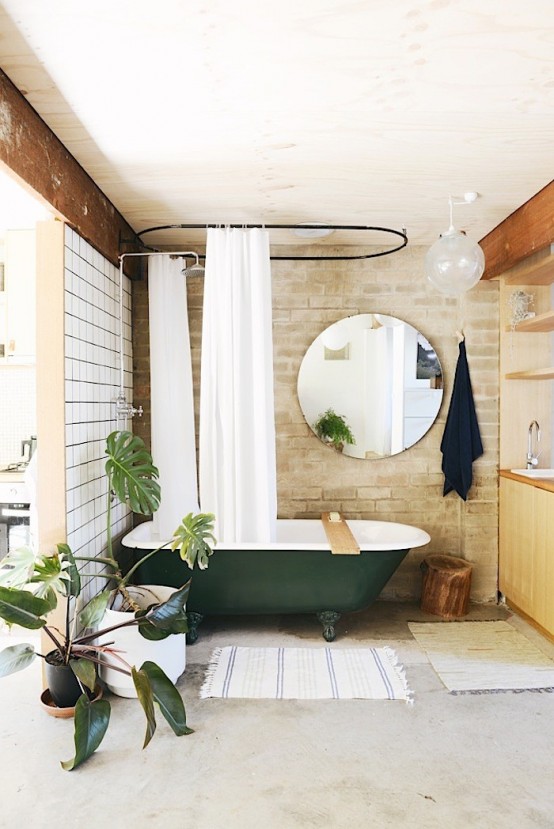 Chic brick bathroom design with a retro green bathtub