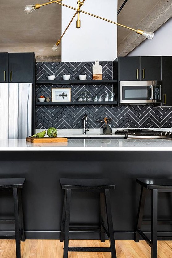 A chic black kitchen with white countertops, a black herringbone backsplash, and an elegant gold-plated chandelier is elegant and sophisticated
