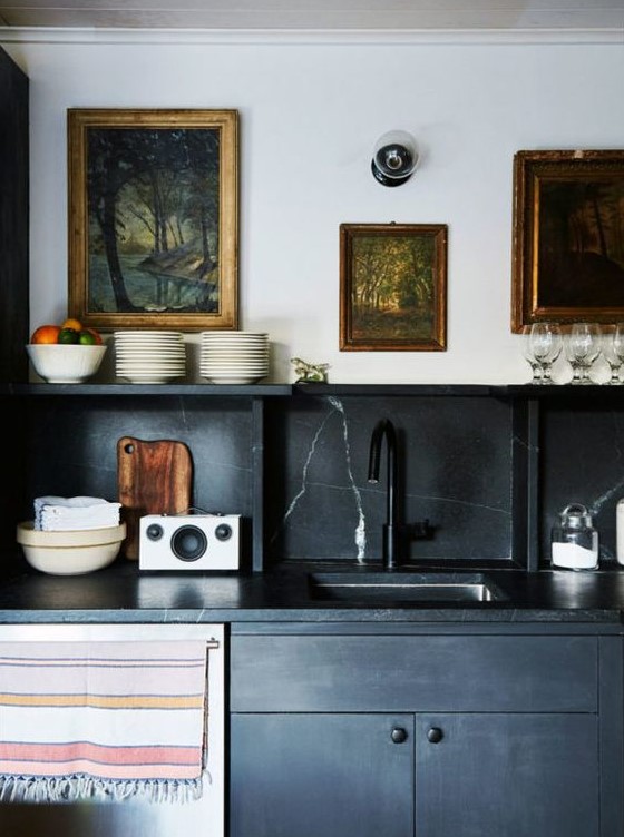 A vintage-style black kitchen with a black marble backsplash and countertops for a sophisticated touch