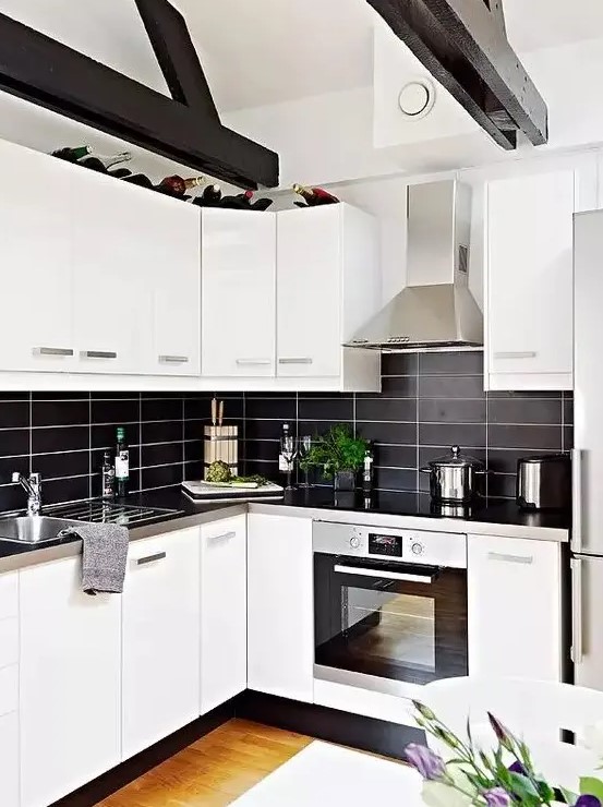 A modern, contrasting kitchen with white cabinets, a black stacked tile backsplash, and metal countertops looks particularly striking