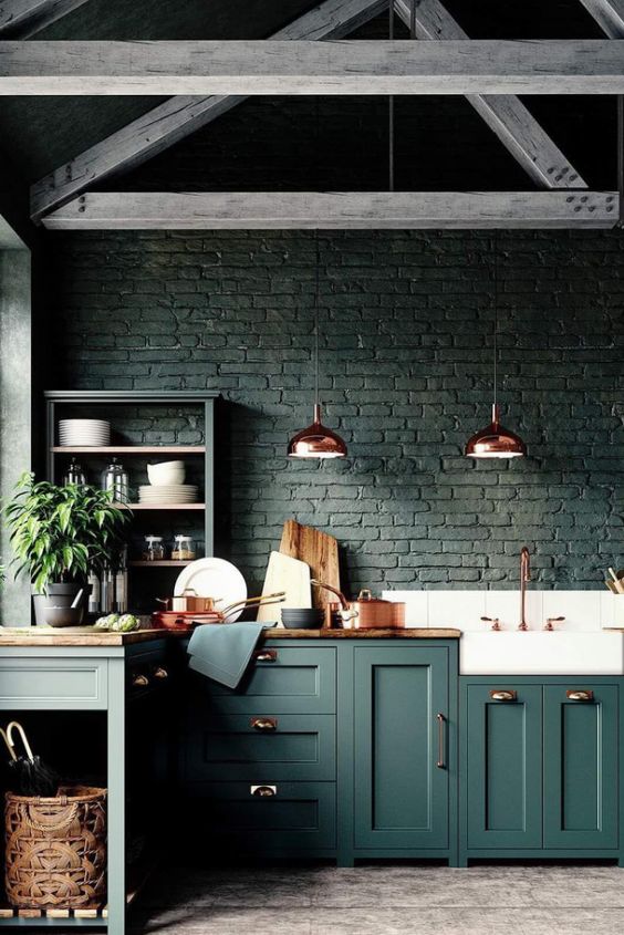 A black brick backsplash matches the forest green cabinets and wood countertops, creating a moody atmosphere in the room