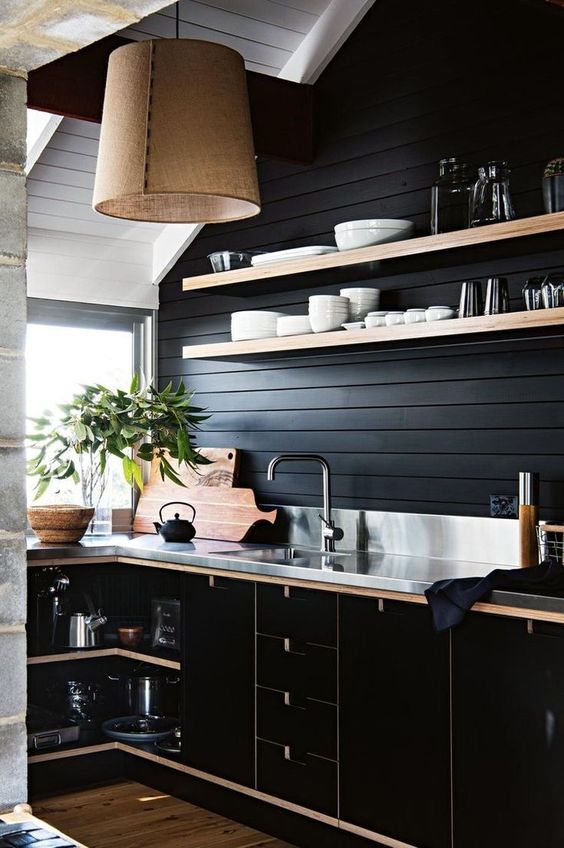 A black shiplap backsplash is an affordable idea that complements the black plywood cabinets and a metal countertop