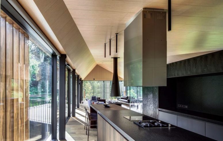 A black metal backsplash and matching worktop help create a minimalist and atmospheric kitchen design