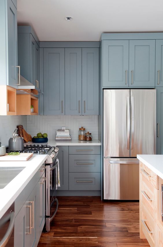Light blue vintage kitchen with metal handles and white countertops