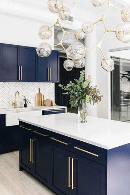 very dark blue kitchen cabinets with white countertops and white herringbone tiles