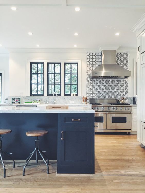 A neutral kitchen is made chic with a navy kitchen island and window frames