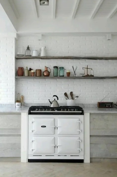 A white brick wall gives the room structure while also matching the neutral kitchen decor