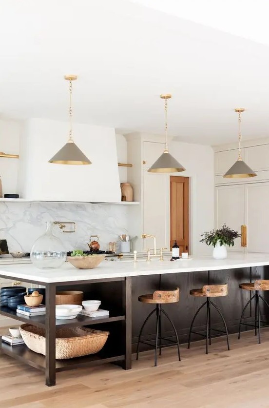 a chic farmhouse kitchen with white shaker-style cabinets, a dark-stained kitchen island with open shelving and gray pendant lamps
