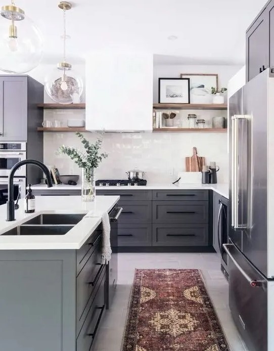 a modern farmhouse kitchen with gray cabinets, a white hood and tile backsplash and white countertops and a boho rug