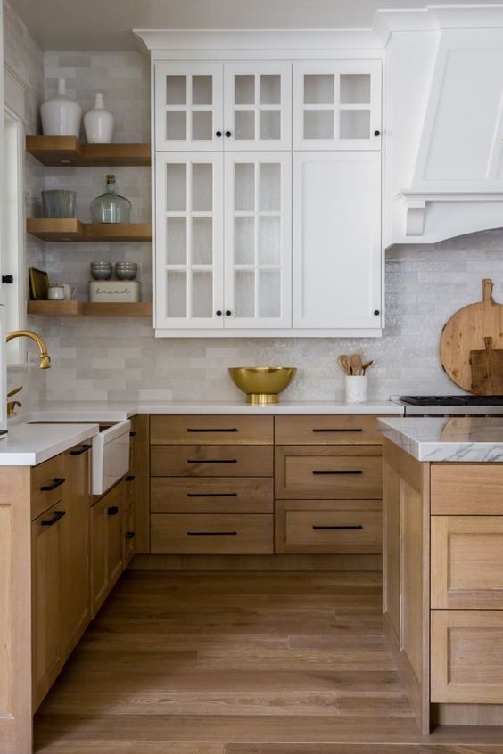 a modern farmhouse kitchen with stained and white cabinets, white stone countertops, a thin tile backsplash and open shelving
