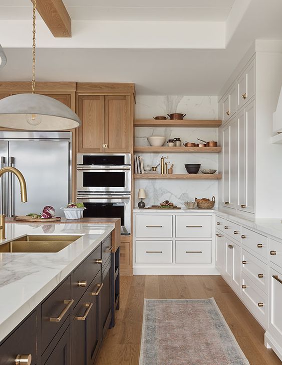 a modern farmhouse kitchen with white cabinets, a black island, white stone countertops, open shelving and stained storage units