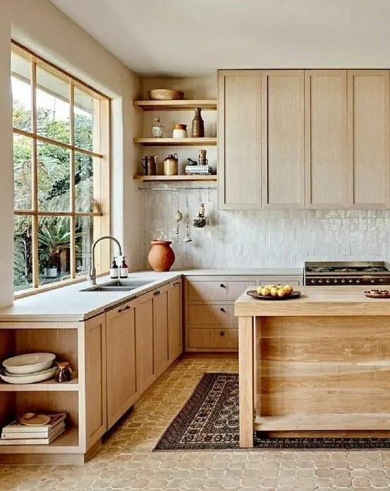 a natural-looking kitchen with light-stained cabinets, a white zellige tile backsplash, white stone countertops, open shelving and a wooden kitchen island