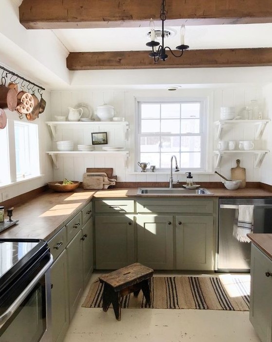 a relaxed farmhouse kitchen with white cambered walls, lime green cabinets, butcher block countertops and wood beams