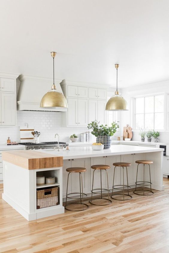 a white modern farmhouse kitchen with shaker cabinets, a large kitchen island with storage, a white tile backsplash and hanging lights