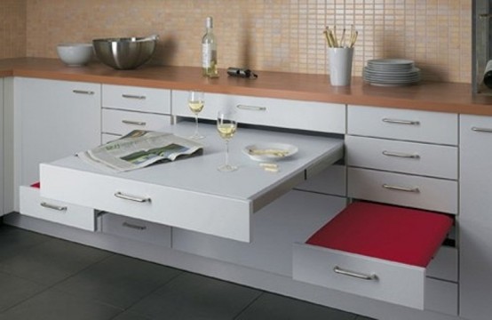 a small modern kitchen with drawers including a table and seats that can be hidden at any time