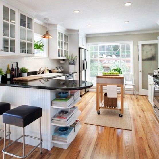 a small modern farmhouse kitchen with white cabinets, black countertops, leather stools and a wooden kitchen island on wheels
