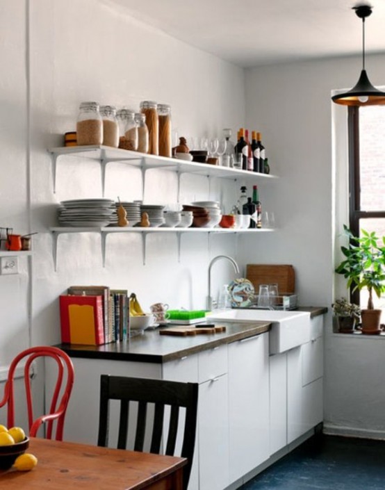 a small modern kitchen with white cabinets, open shelves, a dining area with mismatched chairs