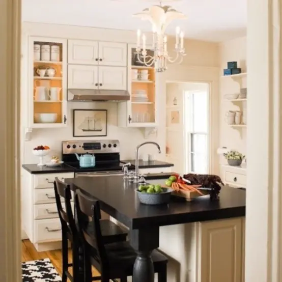 a stylish farmhouse kitchen with white cabinets, black countertops and an elegant chandelier