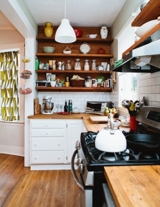 a small modern kitchen in white and richly stained wood, with lots of open shelves and white tiles
