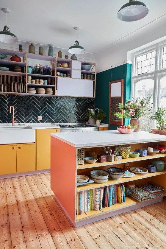 A colorful, eclectic kitchen with emerald green walls, a dark green chevron tile backsplash, statement cabinets and open shelving