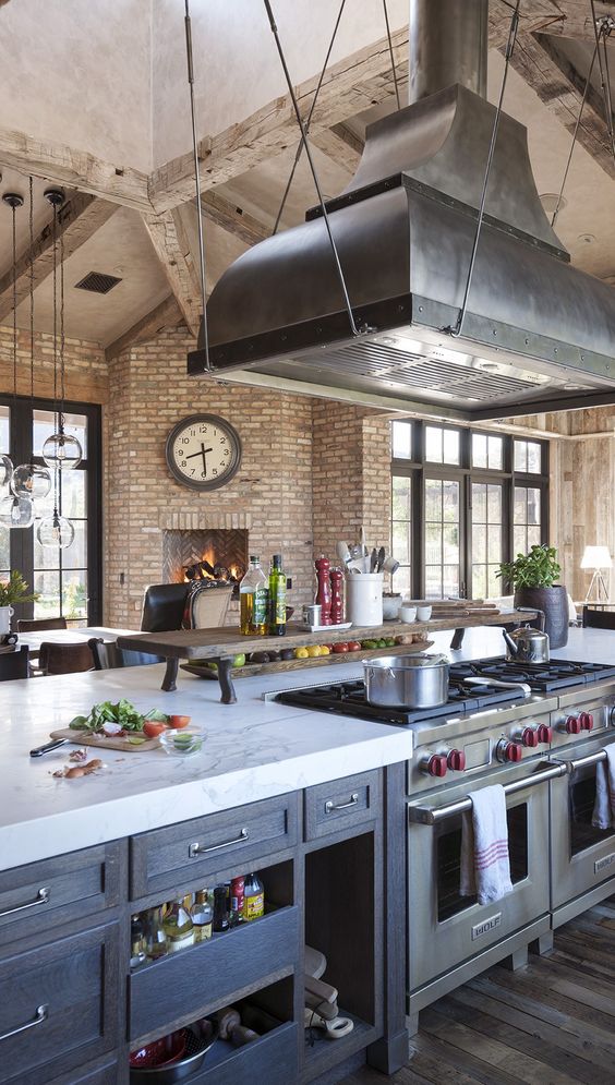 a fantastic, eclectic kitchen with brick walls, blue cabinets and metal appliances, pendant lamps and striking decor