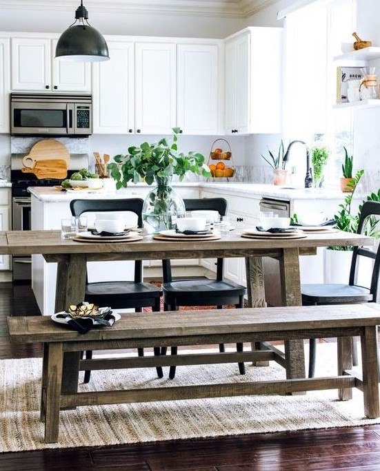 a fresh, modern white kitchen with a rustic dining area with benches and black accents for drama