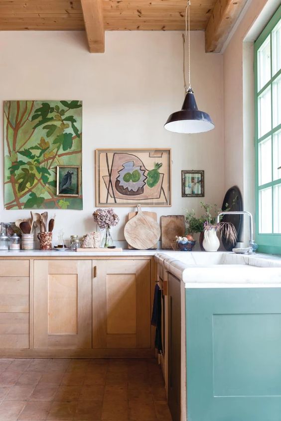 an airy, eclectic kitchen with stained and lime green cabinets, a gallery wall, pendant lamps and some decor