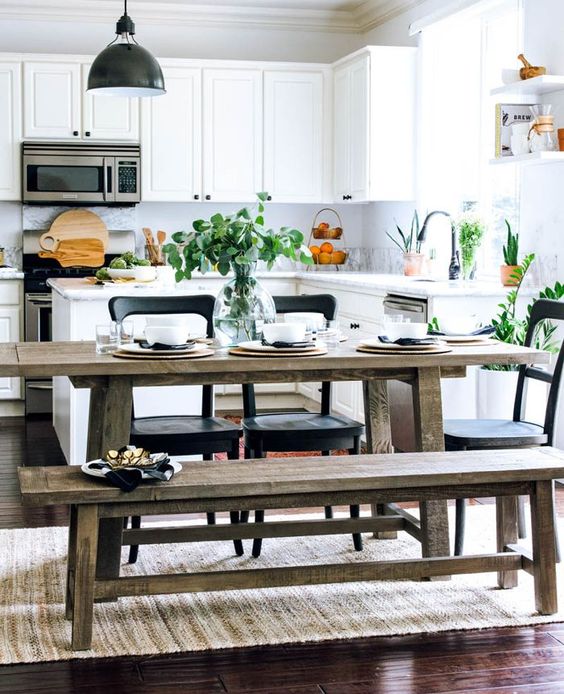 A fresh, modern white kitchen with a rustic dining area with benches and black accents for drama