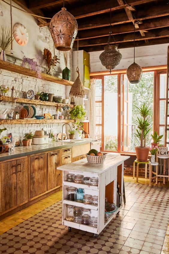 A rustic kitchen with a boho vibe featuring Moroccan lanterns, wooden cabinets and a shabby chic kitchen island