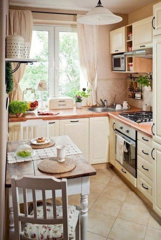 a neutral French country-style kitchen with a tiled splashback, neutral textiles, a small table and floral-patterned chairs