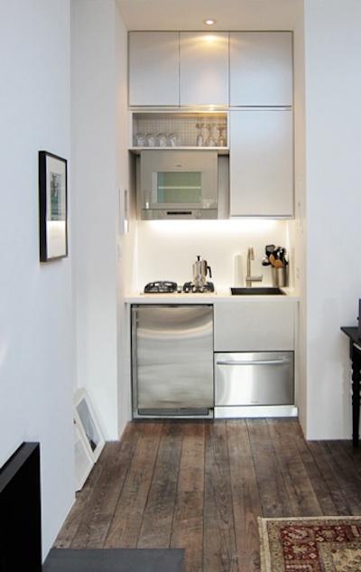 a very small, minimalist kitchen with sleek cabinets, built-in appliances and built-in lights