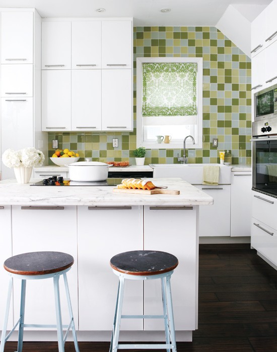 A small white kitchen with sleek cabinets, white stone countertops, and a bright green tile backsplash is fun and cool