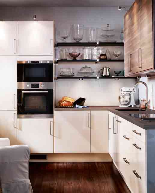 A small white kitchen with dark stained countertops, dark stained shelves and built-in appliances is amazing