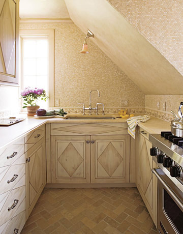 a small French-inspired kitchen with elegant geometric cabinets, mosaic tiles and a ceiling lamp