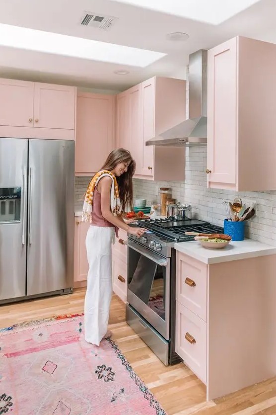 a blush kitchen with shaker style cabinets, a white brick backsplash and white countertops, a pink carpet