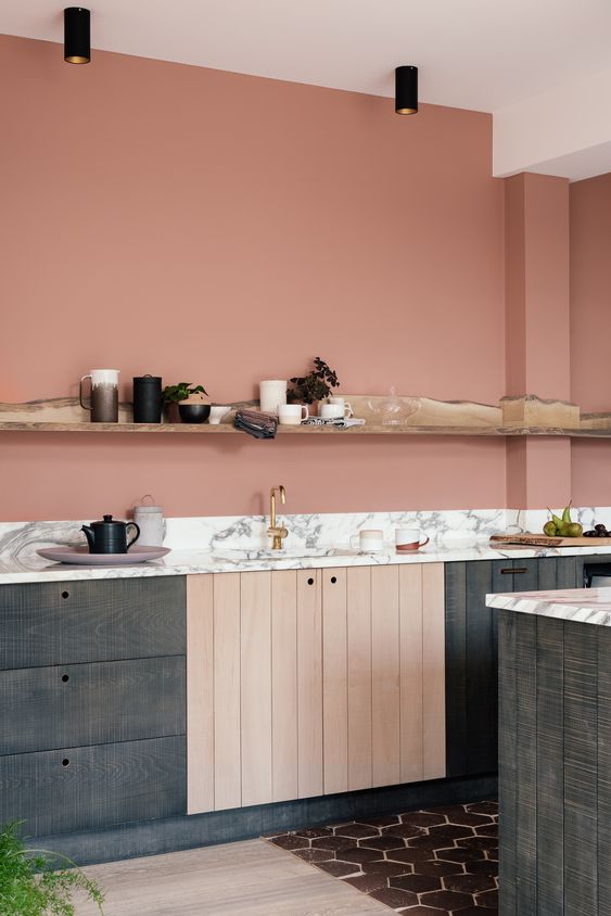 a salmon pink kitchen with dark stained cabinets, a white countertop and a live edge that serves as decoration and storage