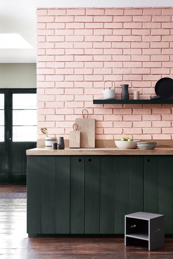 A wall of pink quartz stones and black wooden floorboard cabinets create a stylish look with plenty of texture