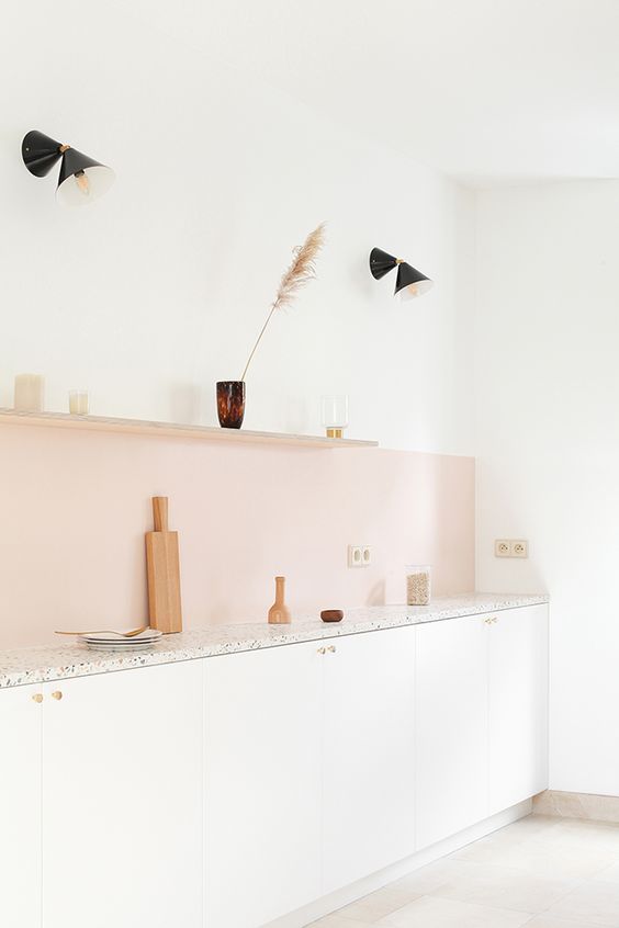 A blush kitchen splashback adds a subtle pop of color to the neutral room