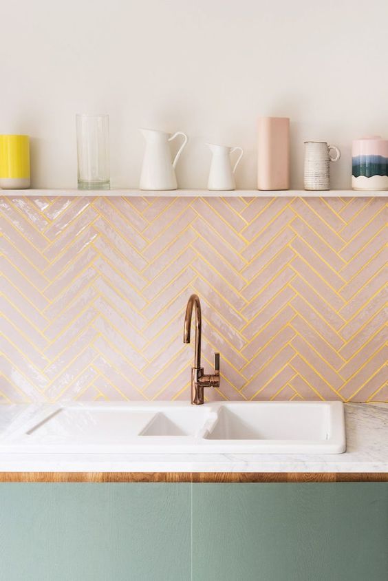 A pink chevron tile backsplash with neon yellow grout adds a bold touch to the kitchen