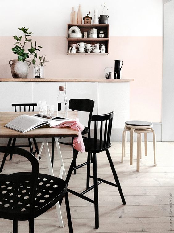 A blush backsplash and white cabinets are highlighted by black furniture