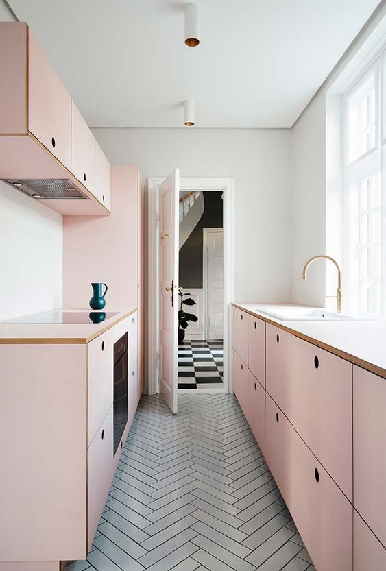 a chic, girly kitchen with simple blush cabinets and a gray tile floor