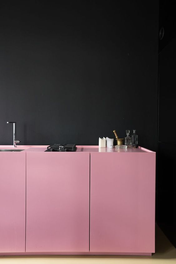 Bold pink cabinets often complement the black walls, creating a cool and bold combination