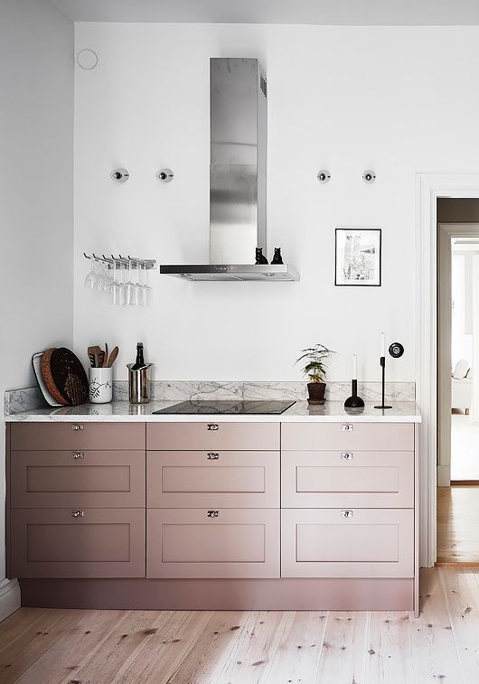 Light pink cabinets add a delicate pop of color to the neutral kitchen