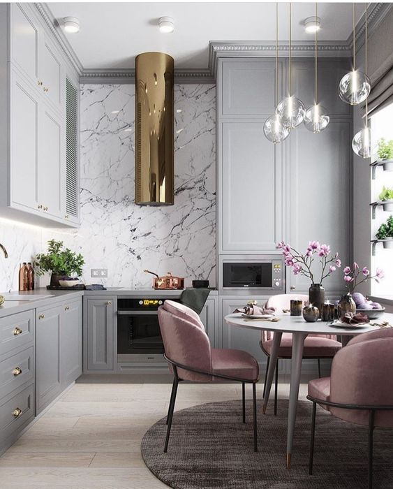 Light pink chairs add color to the monochromatic kitchen with metallic accents