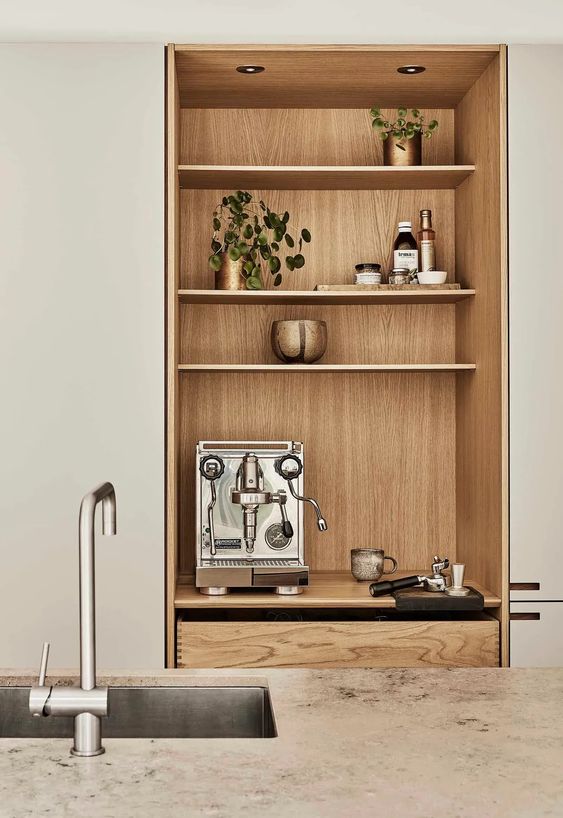 a niche with a built-in cabinet with drawers and open shelves designed to store and display things