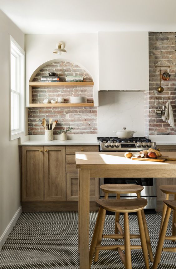 a modern farmhouse kitchen with stained base cabinets, a brick backsplash, and an arched niche with shelves for storage and display